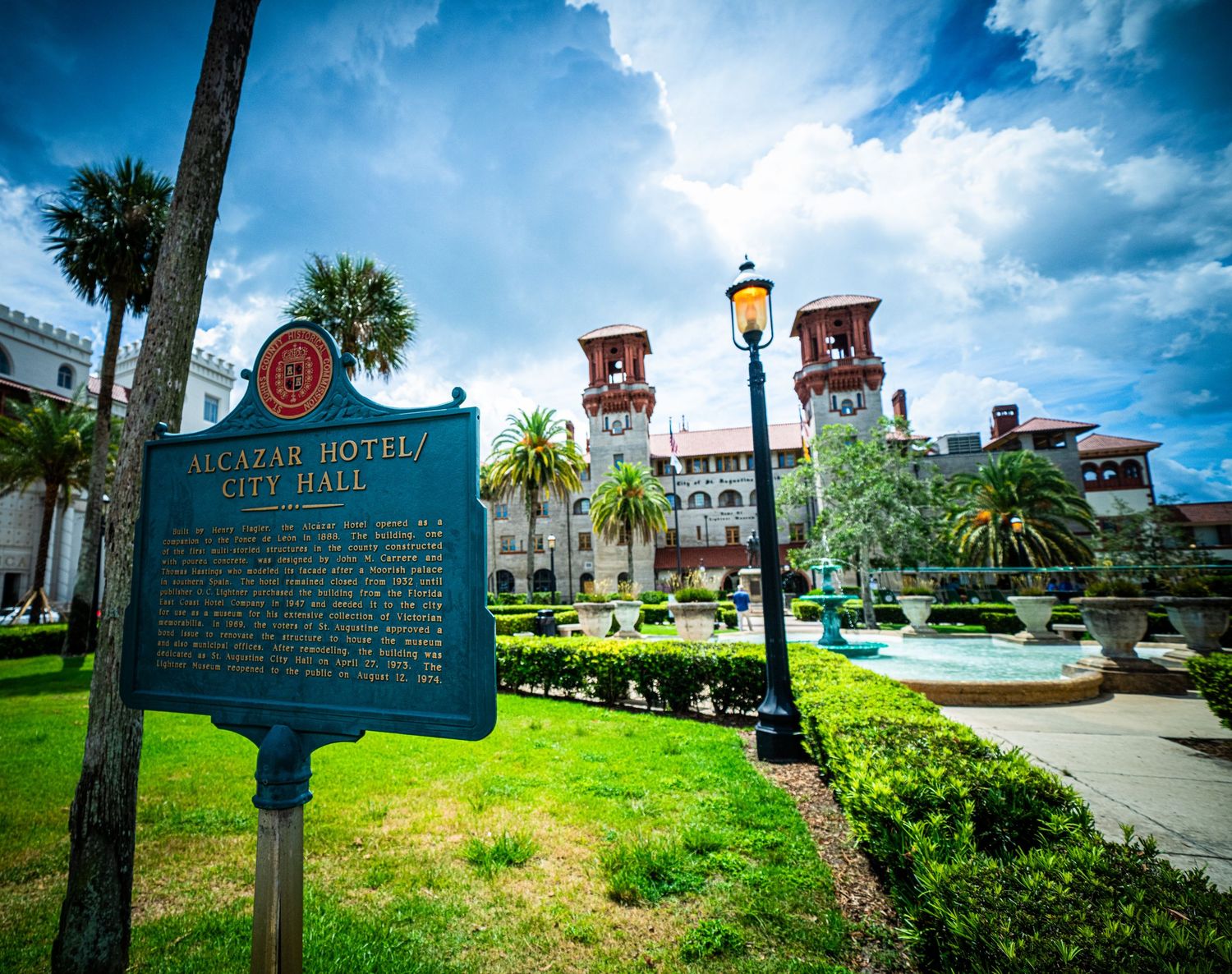 Historic St. Augustine buildings and landmarks with palm trees under bright blue sky.
