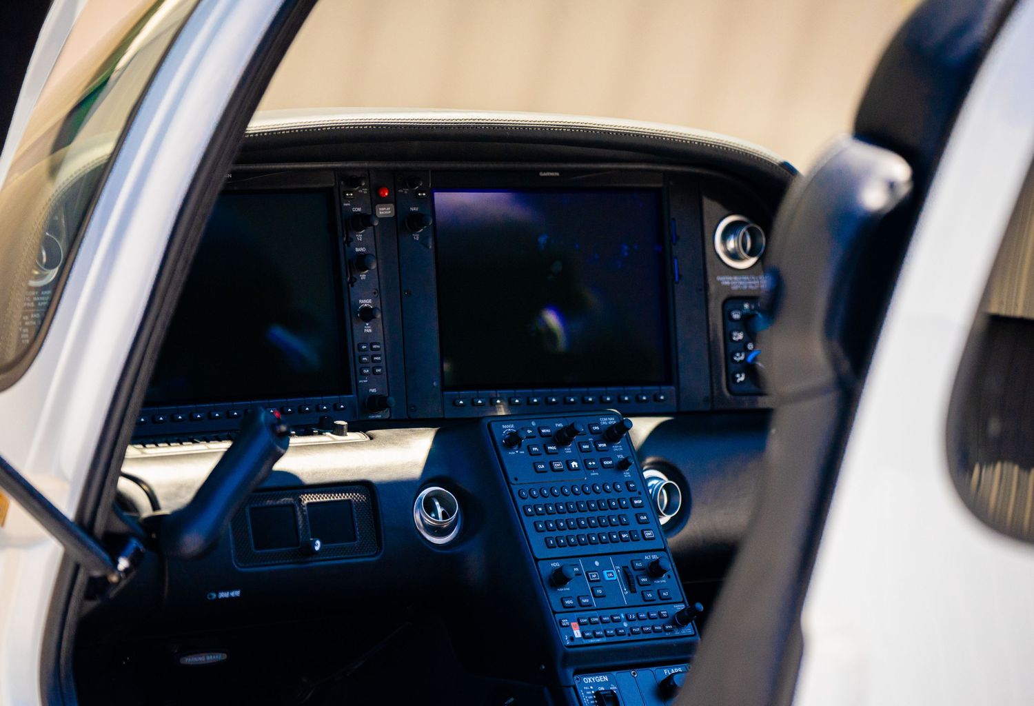 Modern aircraft cockpit interior showing digital instrument panels and controls.