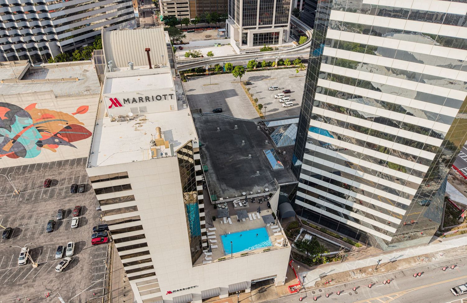 Aerial view of Miami Marriott hotel rooftop pool surrounded by urban skyscrapers on a sunny day.