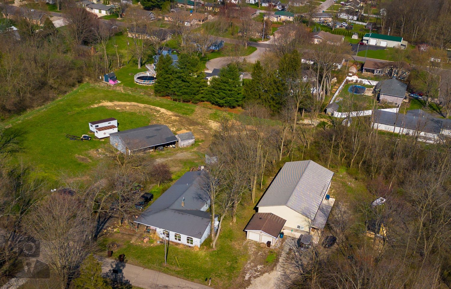 Aerial view of suburban neighborhood with houses and trees during spring or summer.