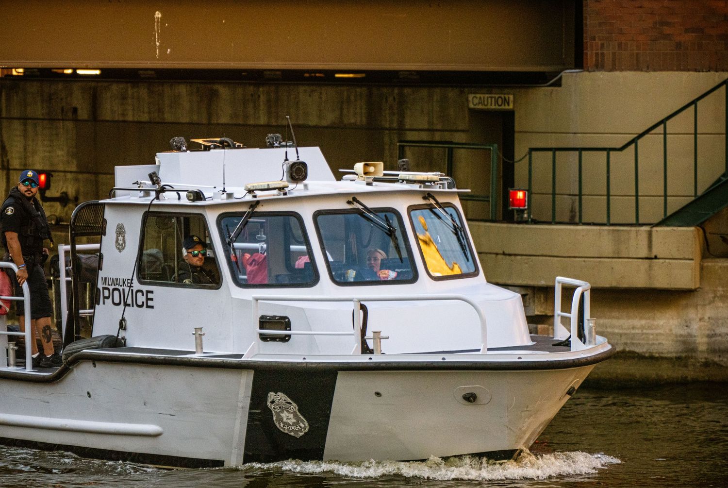 Commercial tour boats lined up at a marina dock near urban buildings.
