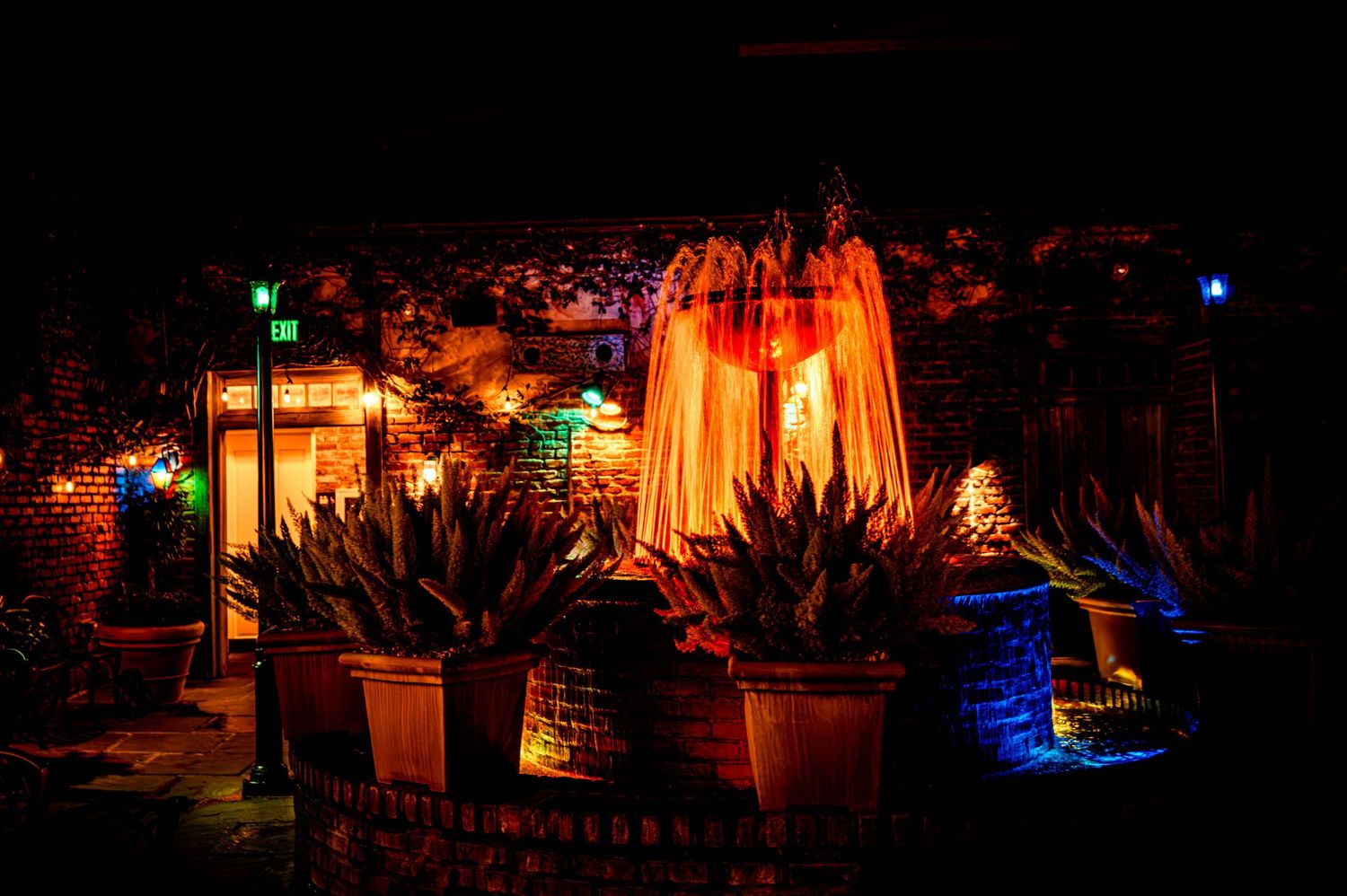 Garden pathway lit with warm orange lanterns and cool blue accent lights creating an enchanting evening ambiance.