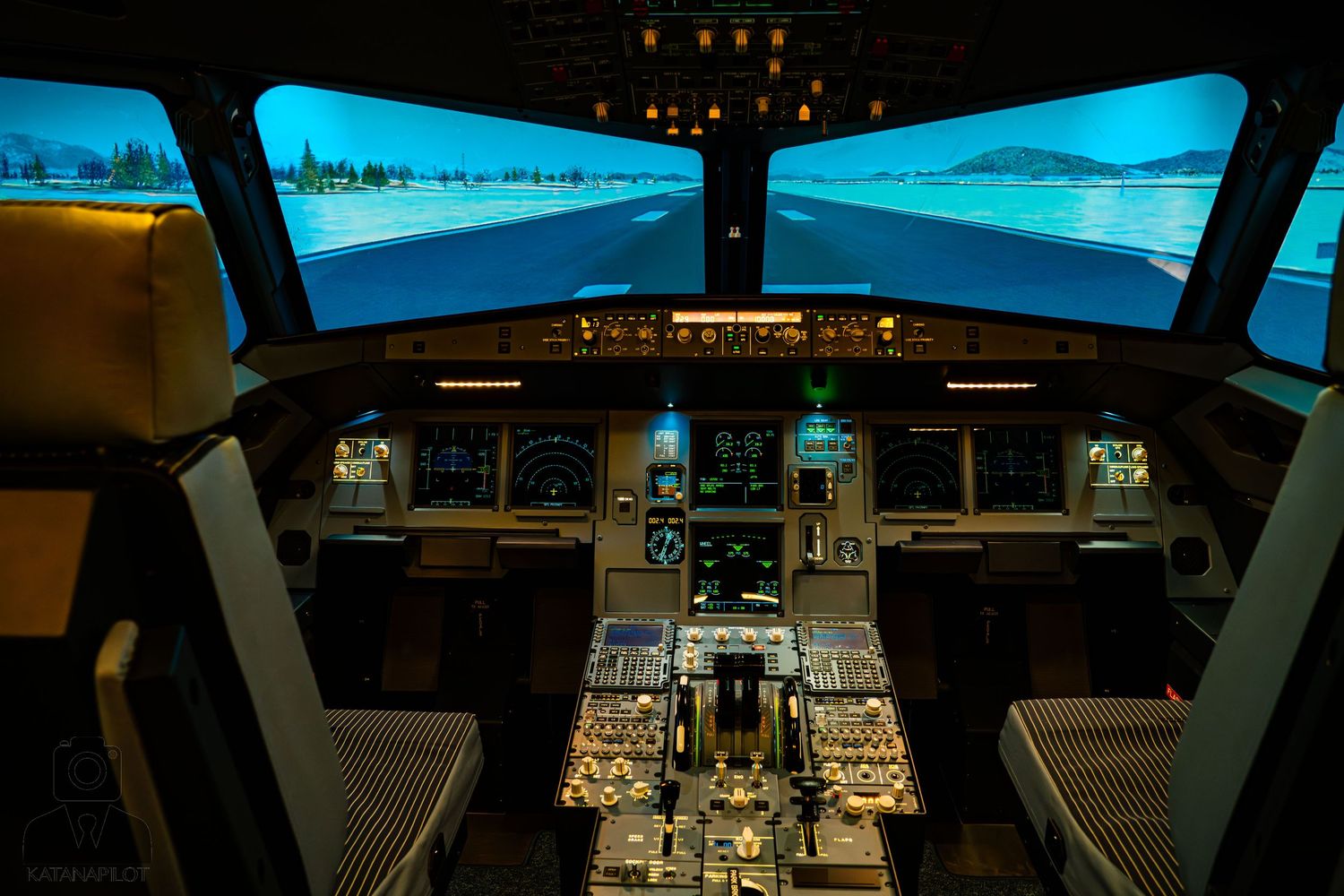 Flight simulator with blue sky visuals displayed across multiple screens.