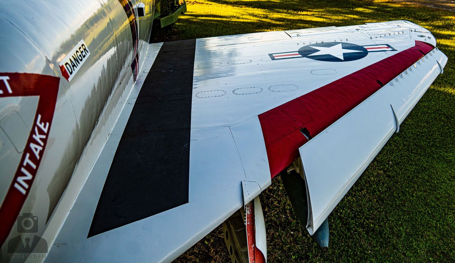 Close-up view of military aircraft wings and markings on display in an outdoor setting.