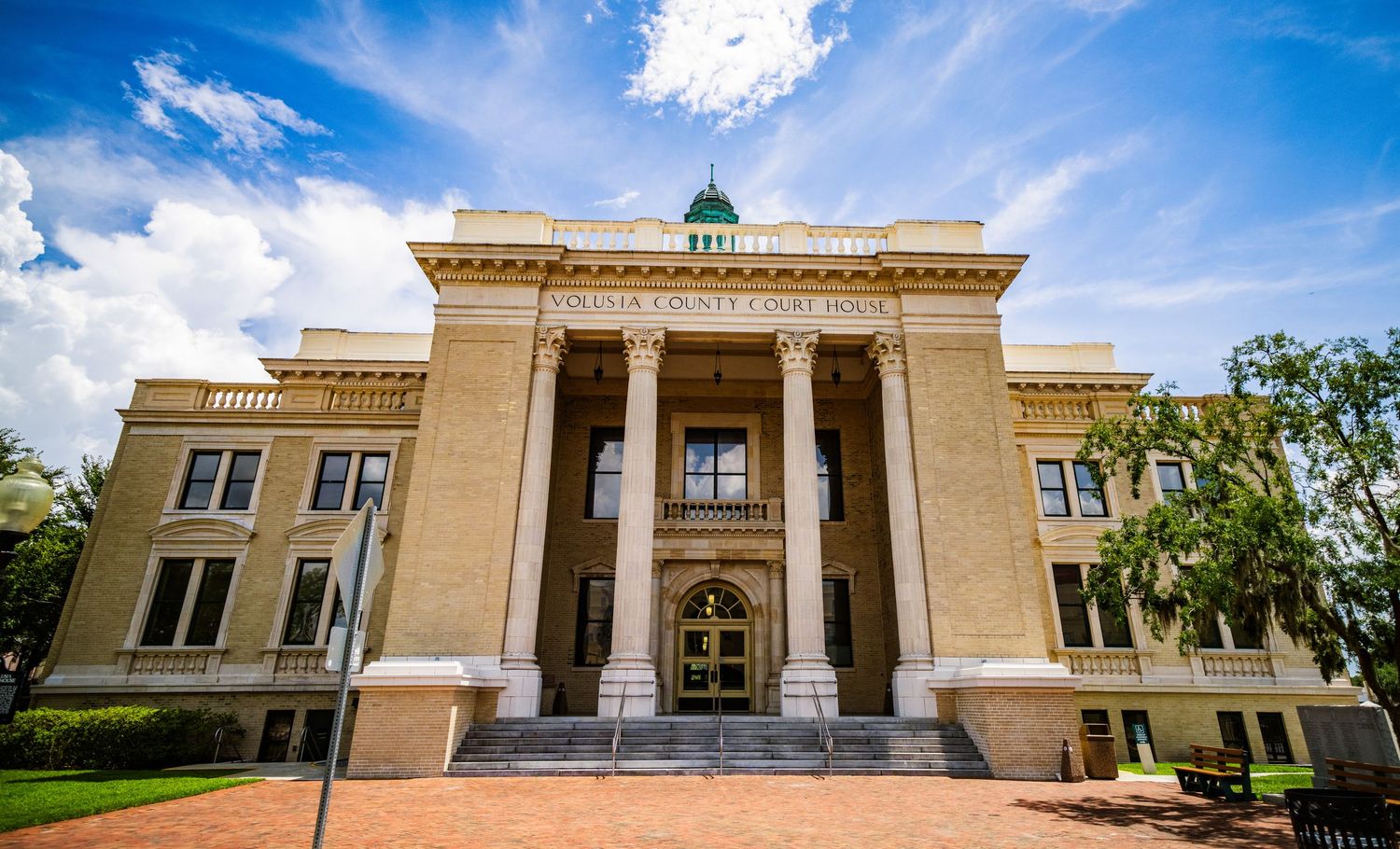 Neoclassical government building with grand columns and domed cupola under blue sky.