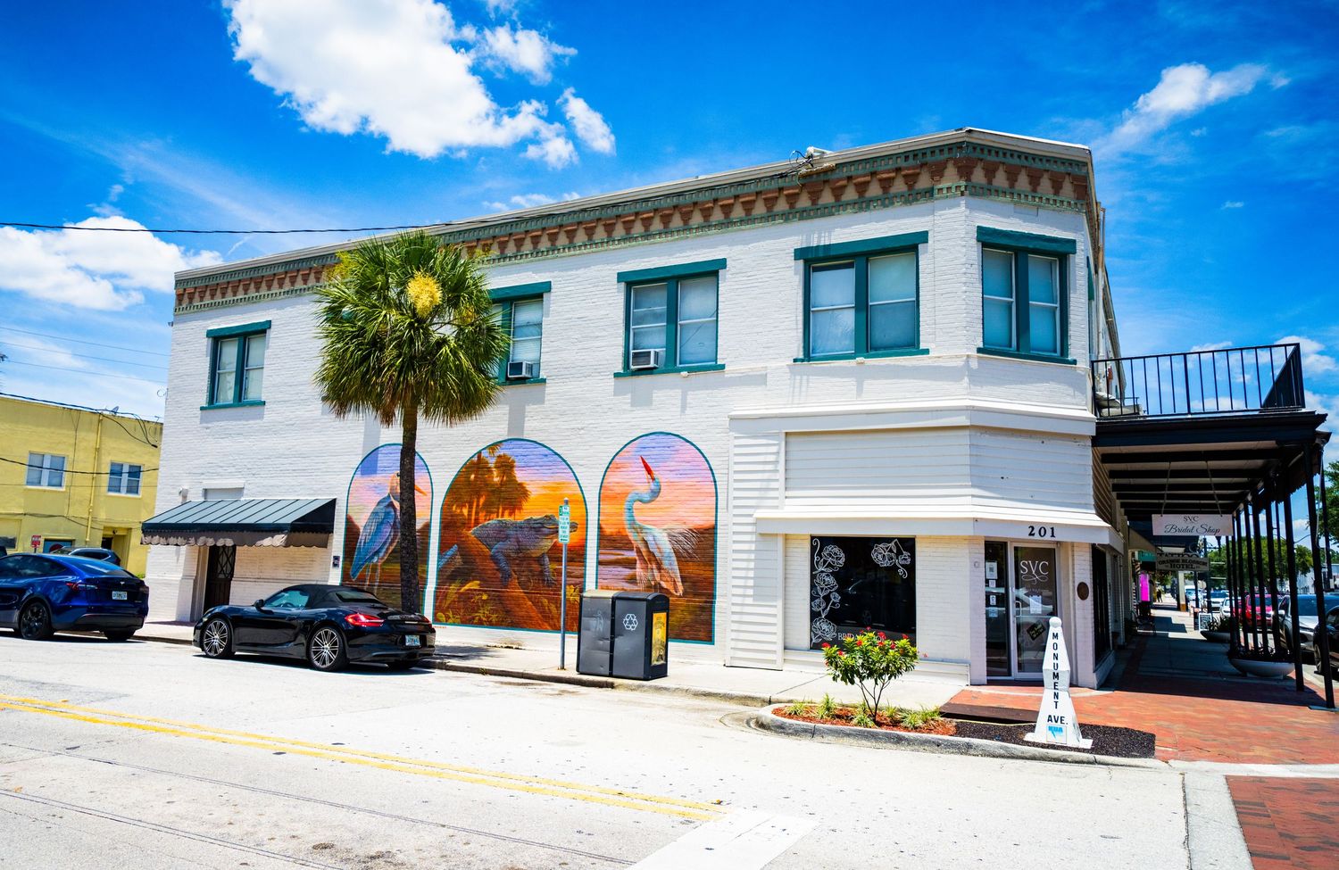 Panoramic view of downtown buildings and palm trees under vibrant blue sky.