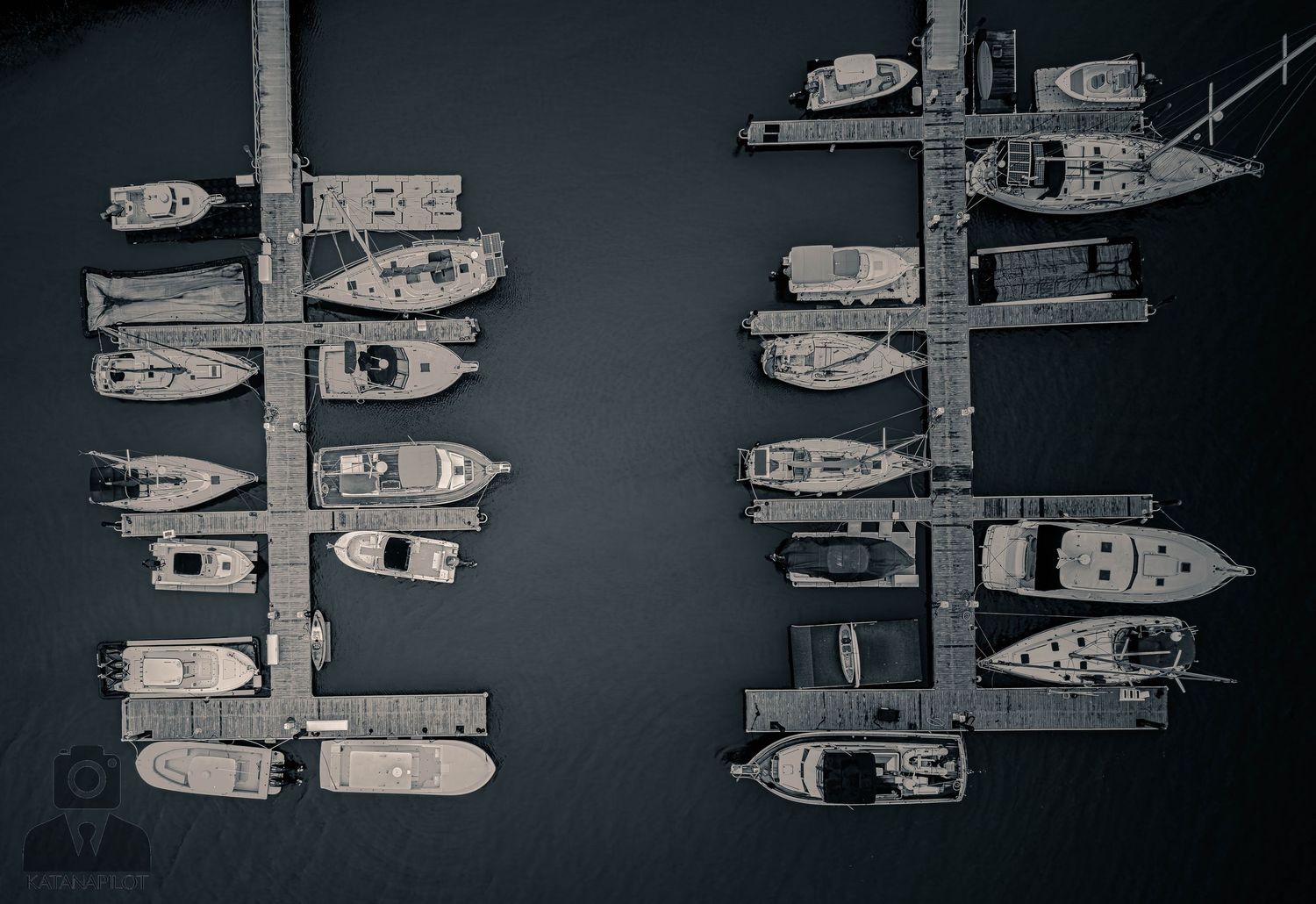 Aerial view of luxury yachts and boats moored in a dark marina at night.