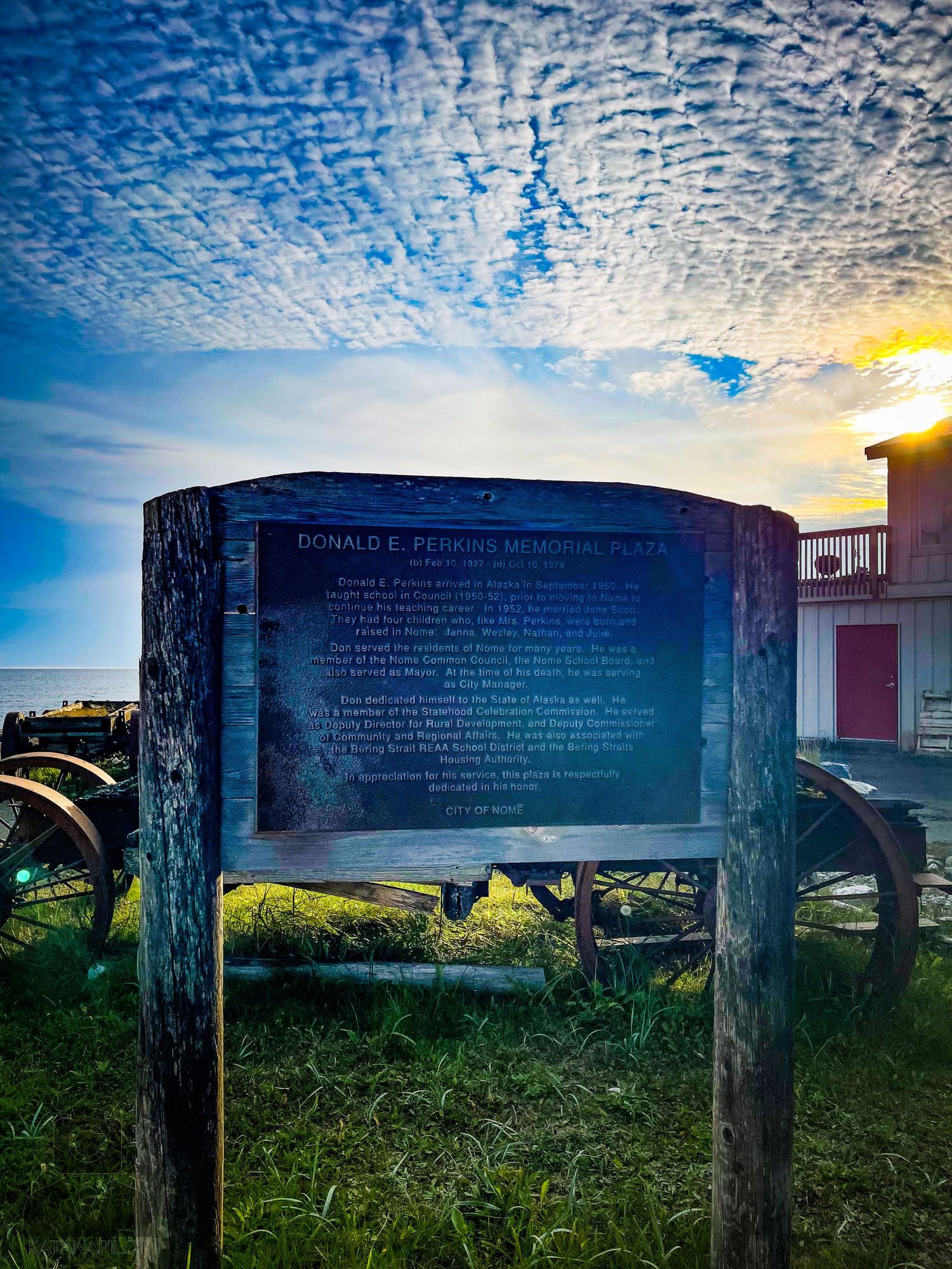 Row of informational plaques mounted on wooden posts against a scenic natural backdrop.