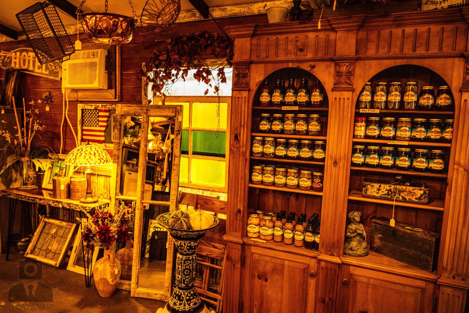 Vintage shop display with wooden shelving filled with old bottles and antique merchandise.