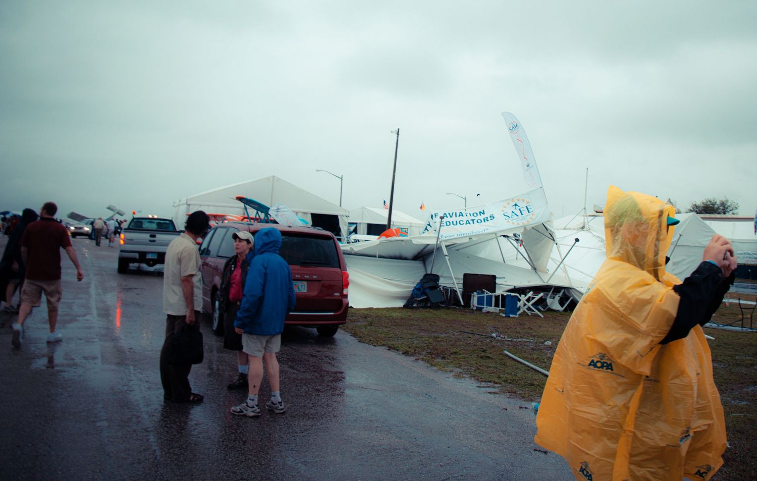 A panoramic sequence showing emergency response vehicles and personnel gathered on a rainy day near a roadway.