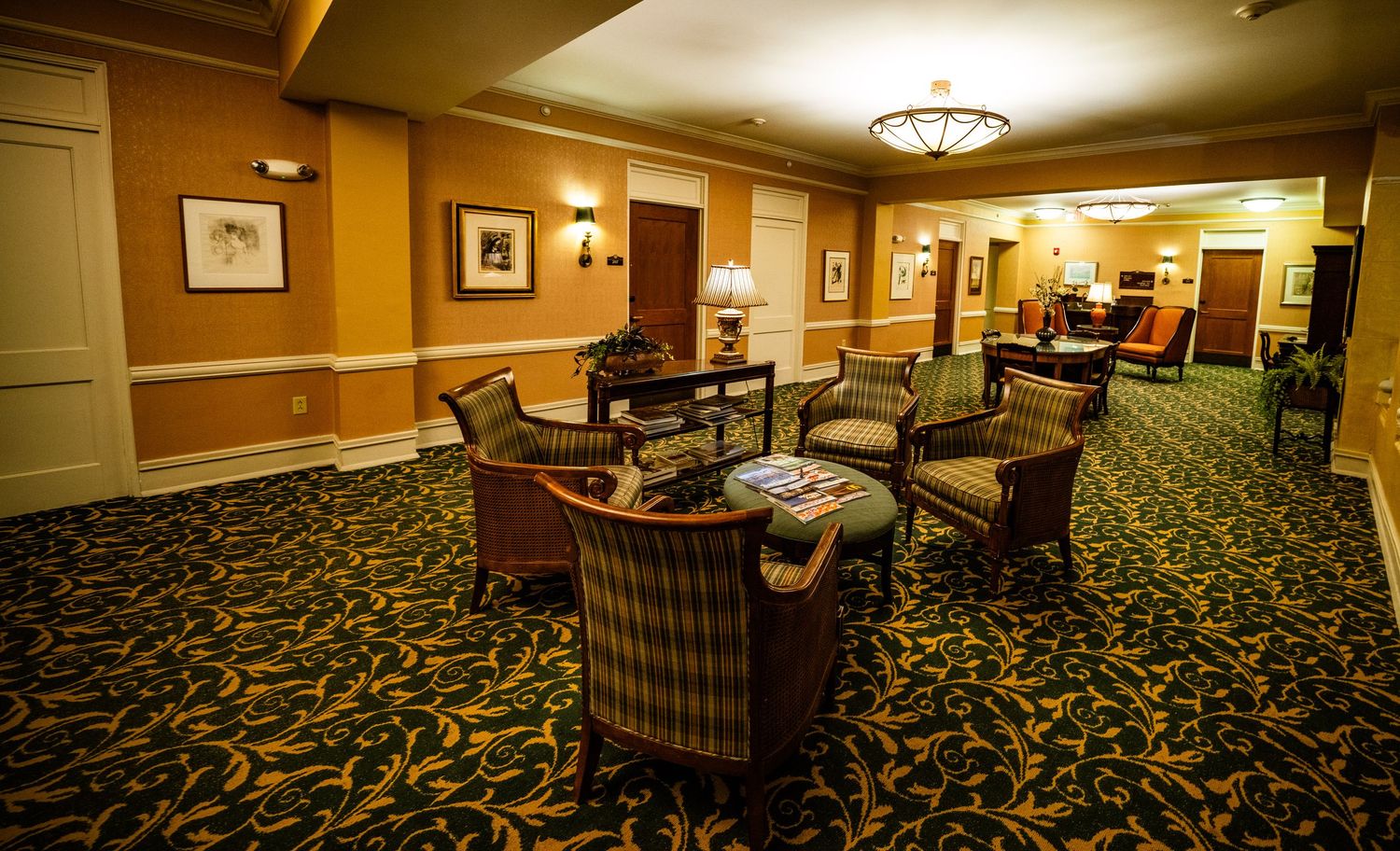 Hotel lobby lounge area with patterned carpet and comfortable seating arrangements.