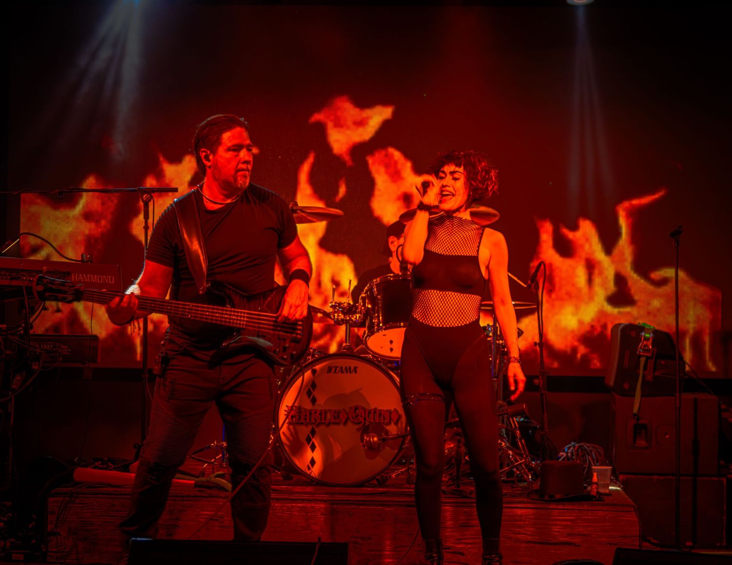 Band performing on stage with dramatic red lighting and silhouetted figures.