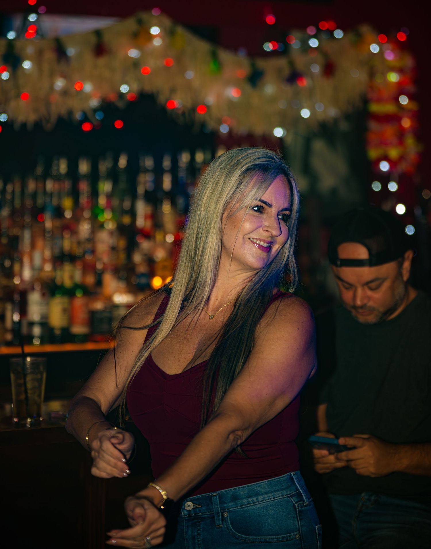 Bar scene with bokeh lights in background showing patrons enjoying evening drinks.