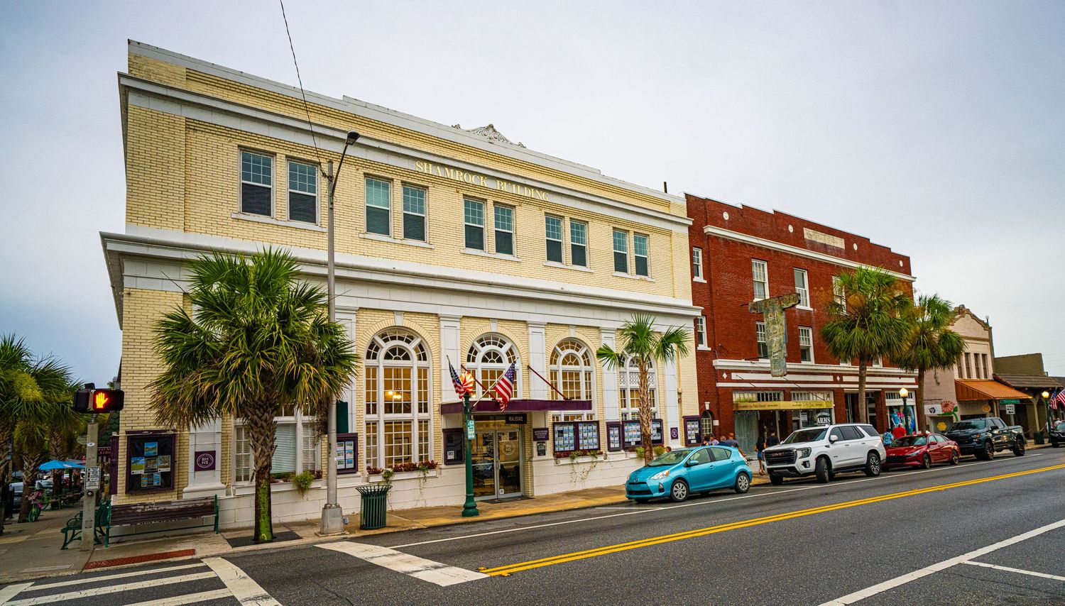 Historic downtown street view with traditional brick buildings and parked cars.