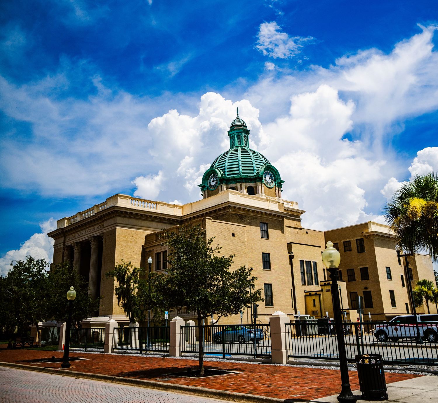 Historic courthouse building with green dome and classical architecture on a sunny day.
