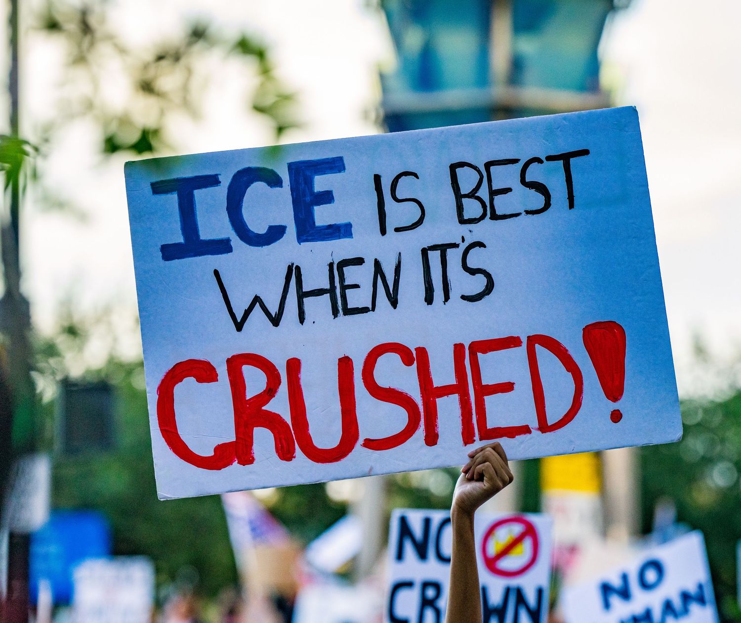 Protest sign with text about ICE displayed at political demonstration.