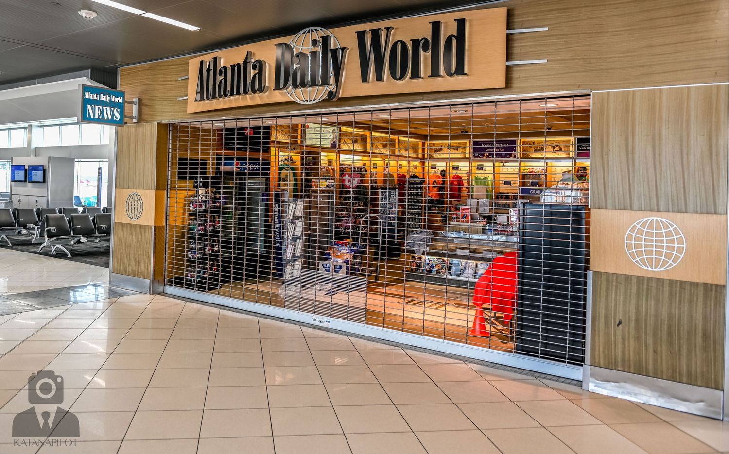 Mall corridor with Daily World signage and wood paneling visible above closed security gates.