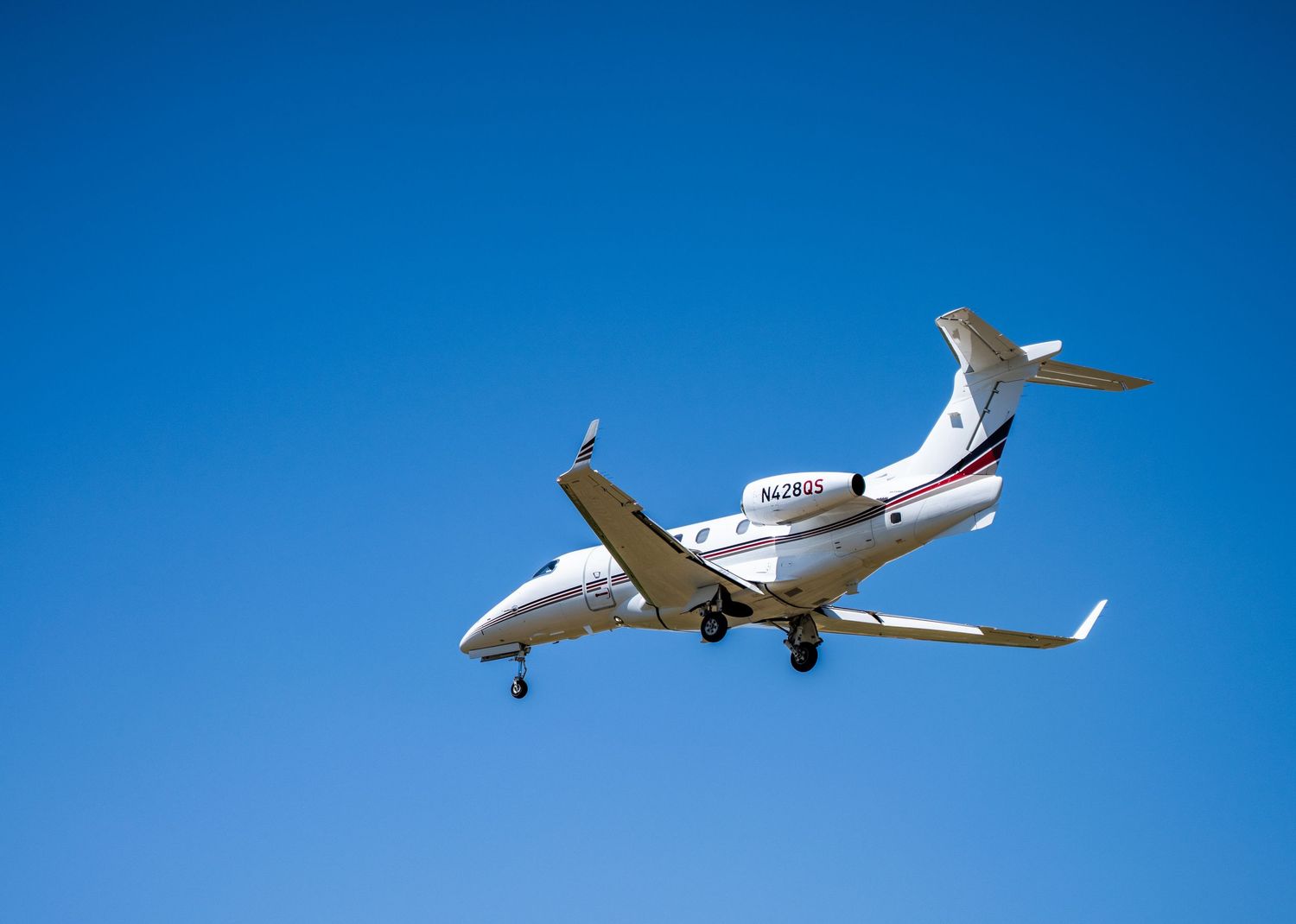 Private jets and small aircraft flying in clear blue sky.