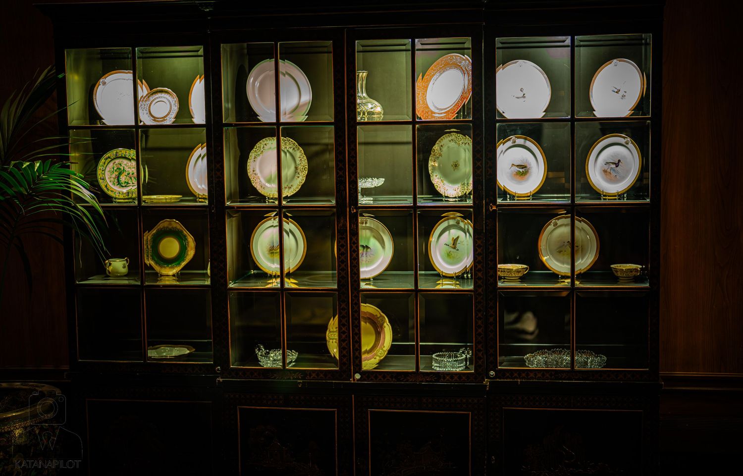 A row of illuminated circular gauges or meters with glowing yellow lights behind dark glass panels.