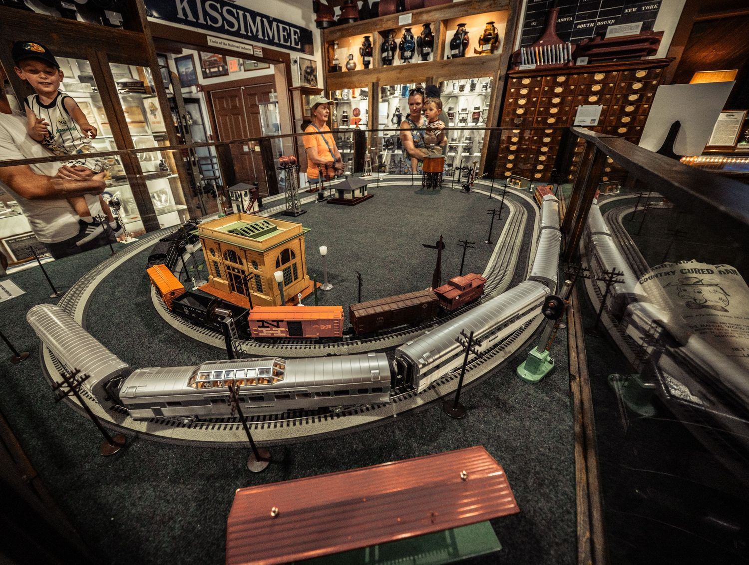 Vintage model train layout display with intricate track setup and detailed scenery in a museum-like setting.