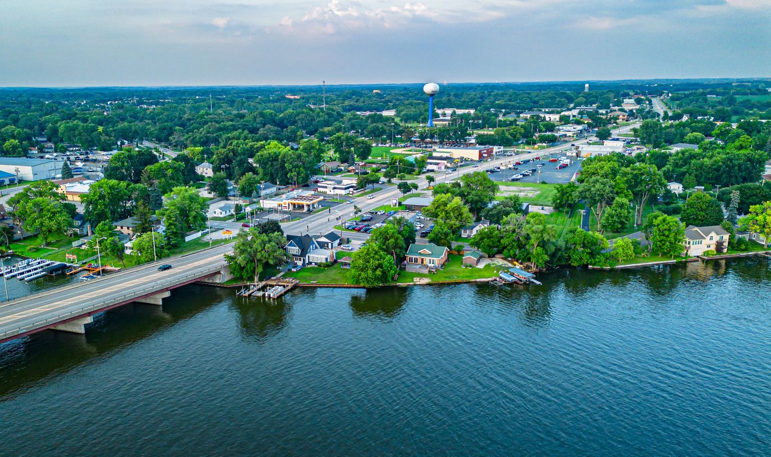 Aerial view of a waterfront town with boats, docks and buildings along the shoreline.