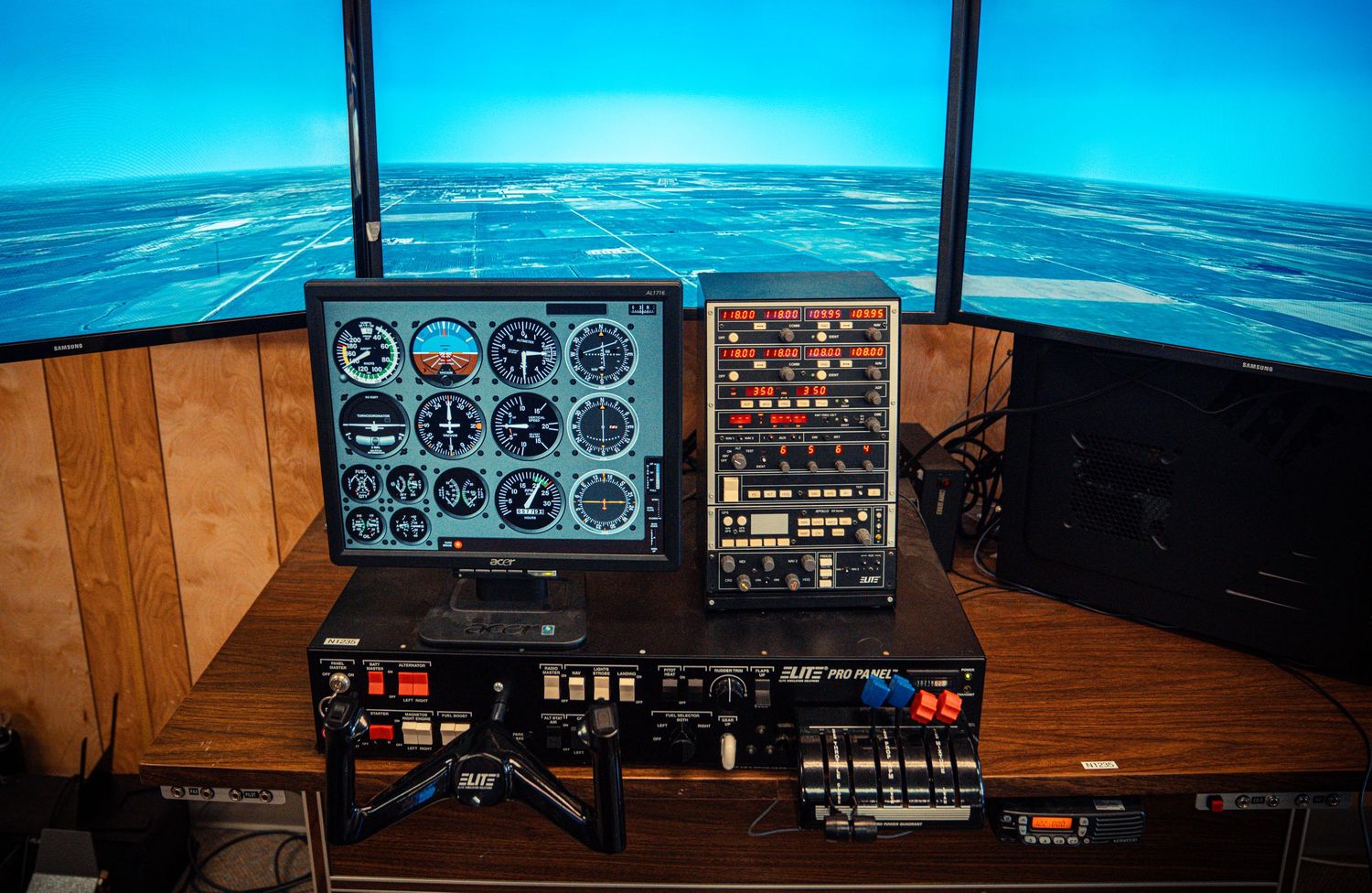 Flight simulator panorama showing instrument panels and virtual horizon against ocean backdrop.