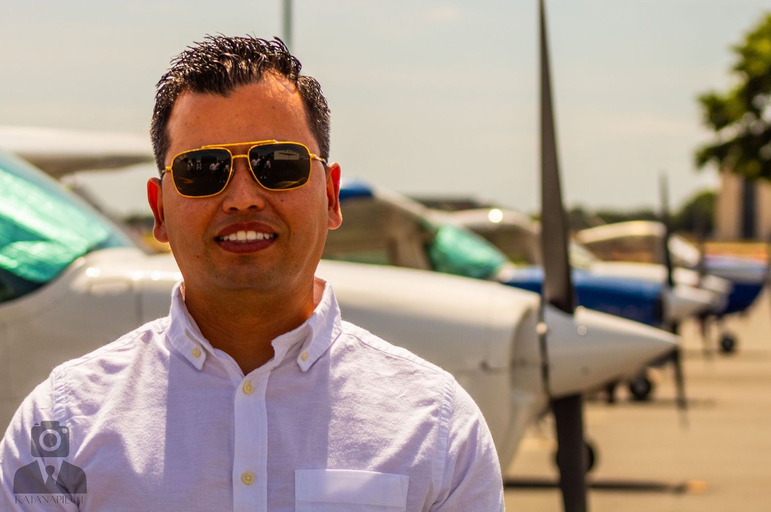 Professional aviation staff posing at airport with aircraft behind them.