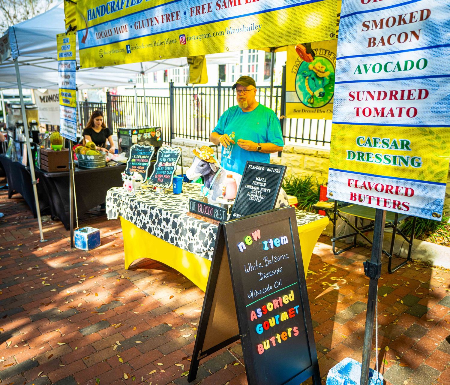 A series of food service signs and displays showing menu items and pricing at an outdoor market or food stand.