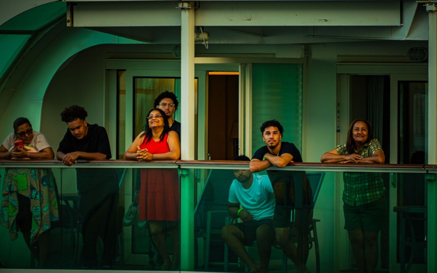 People sitting at tables in a green-lit cafe or restaurant interior.