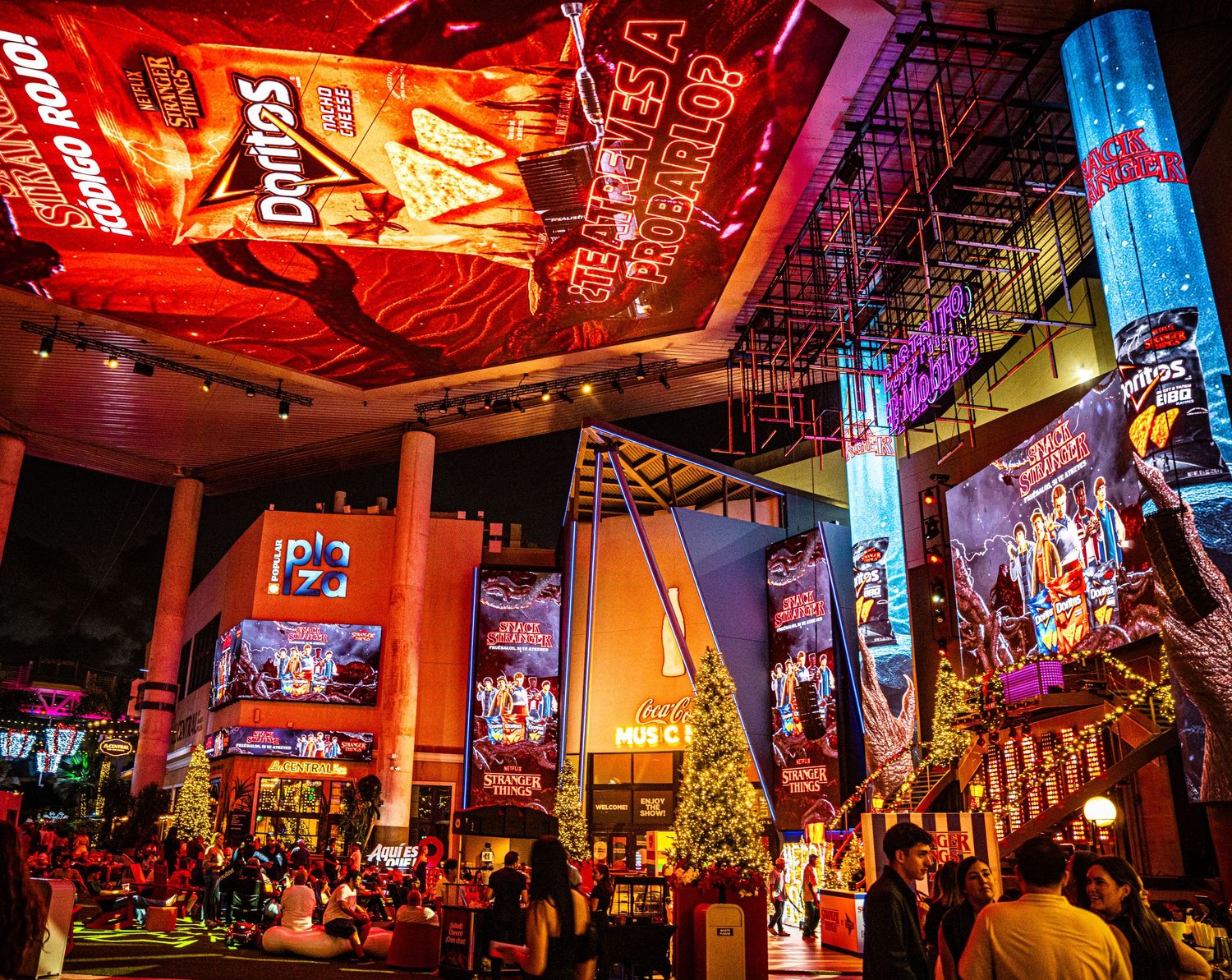 Colorful nightclub interior with vibrant red and blue lighting illuminating a lively dance floor and entertainment space.