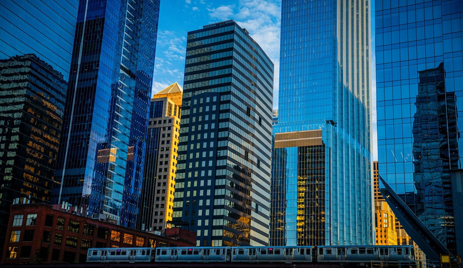 Urban landscape of Chicago's Loop district showing modern high-rise buildings under blue skies.