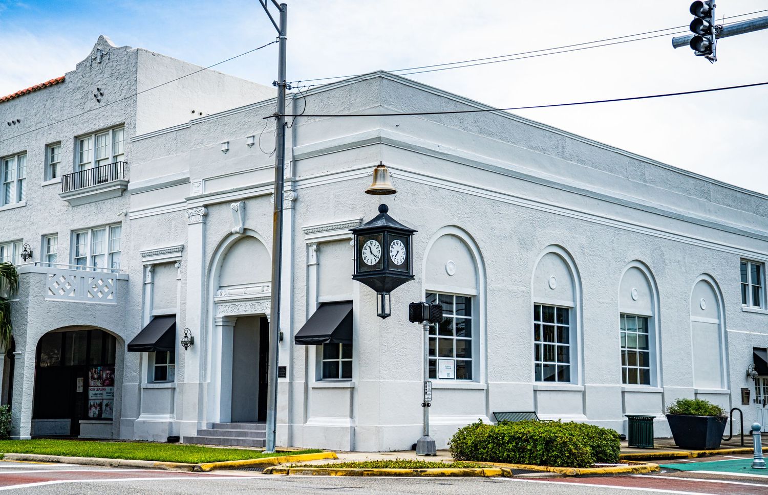 Classic white architectural building with arched windows and ornate lamp post.
