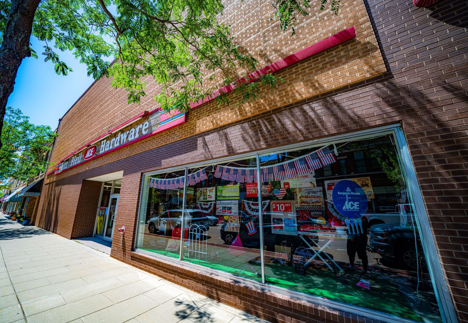 Angled view of a retail storefront with large windows and brick facade in downtown Oshkosh.