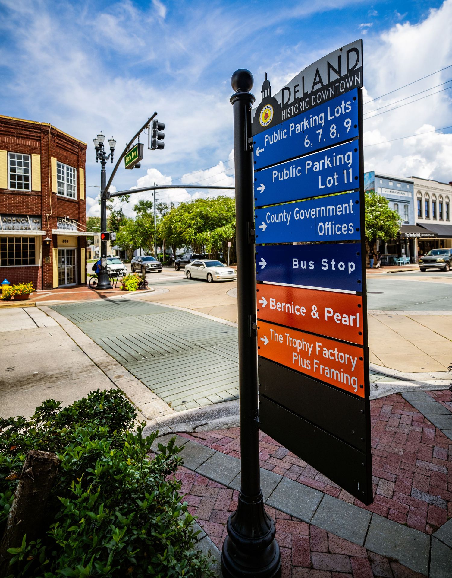 Wayfinding signage for parking and public facilities mounted on decorative black posts.