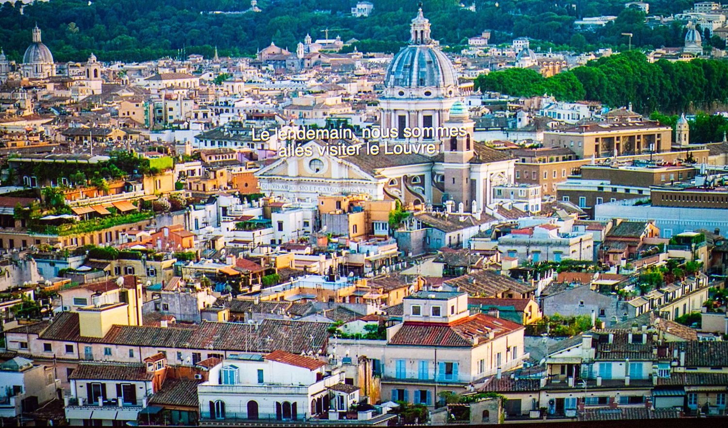 Panoramic cityscape view of a Mediterranean town with white buildings and church domes.