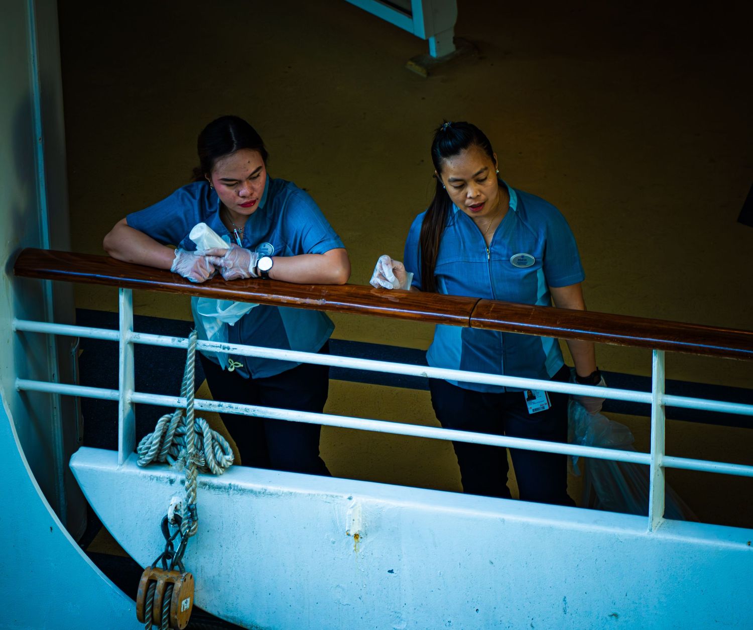 Medical professionals in blue scrubs work at elevated stations in a healthcare facility.