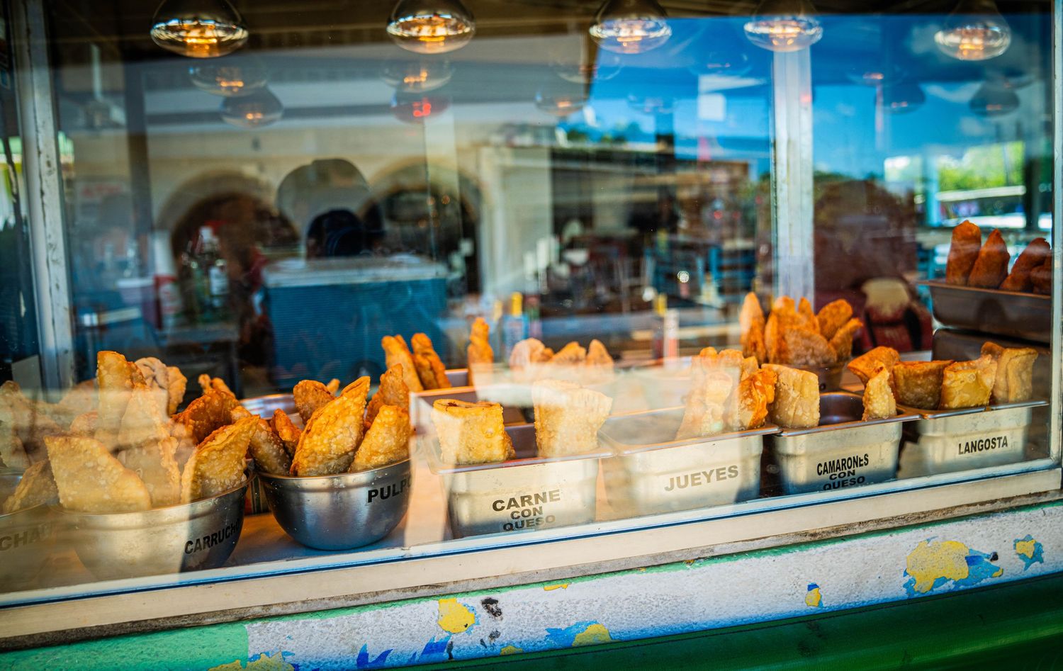 Illuminated bakery display case showcasing fresh pastries and baked goods behind glass windows.