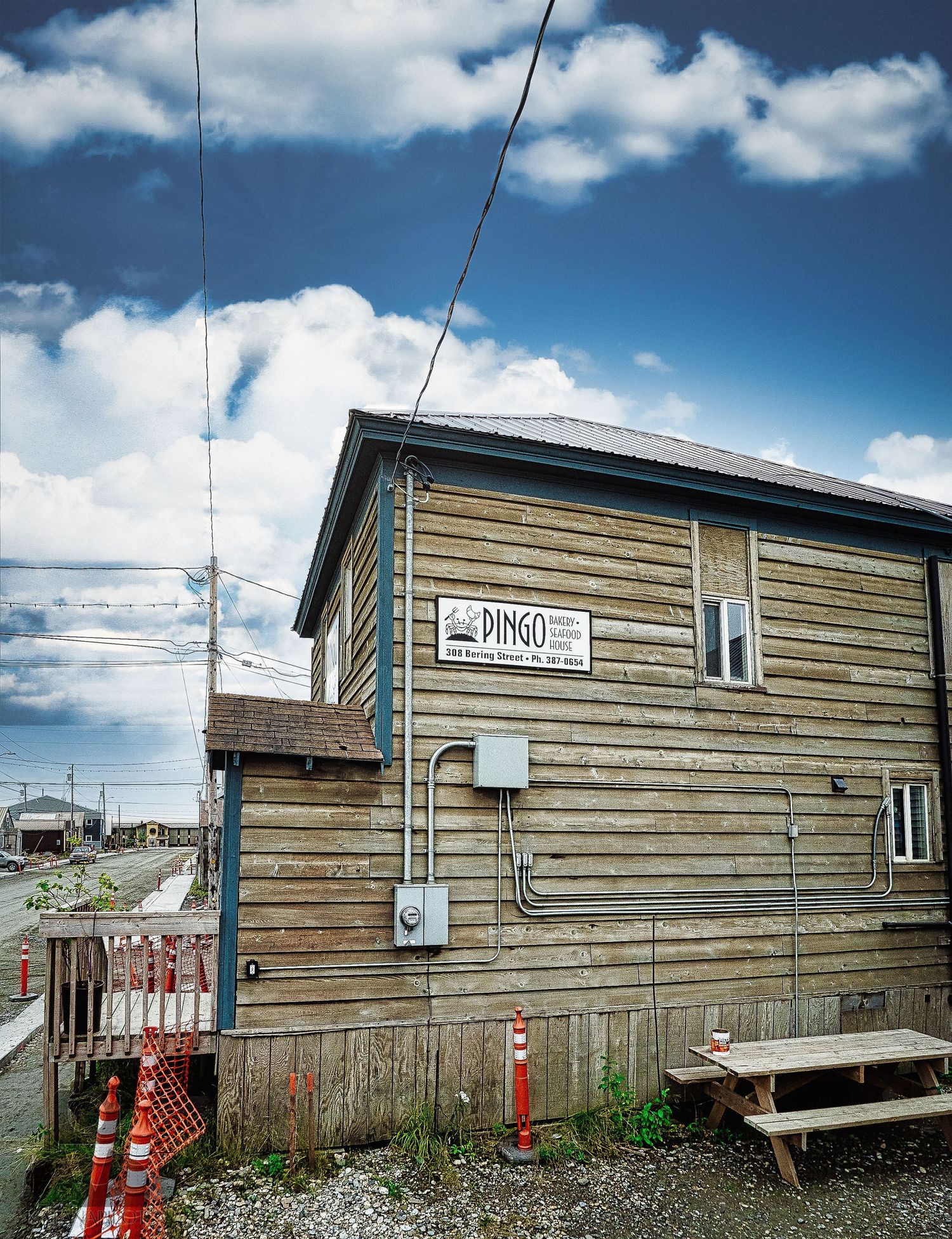 Rustic wooden buildings with horizontal siding in remote northern settlement.