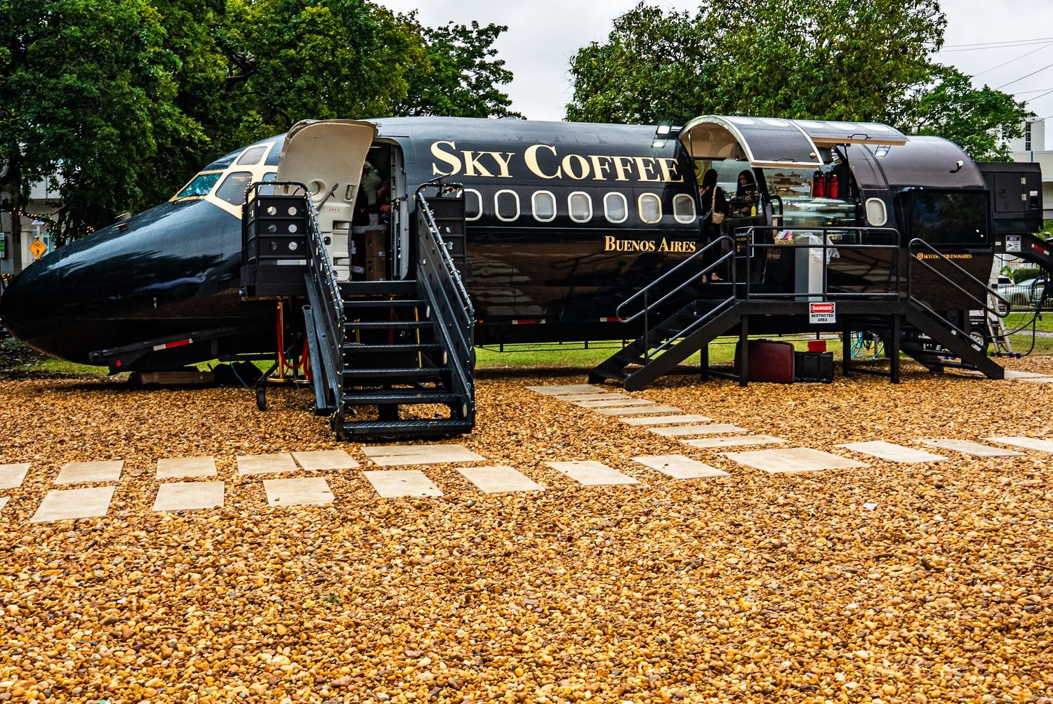 Mobile coffee truck parked on autumn leaves in a park setting.