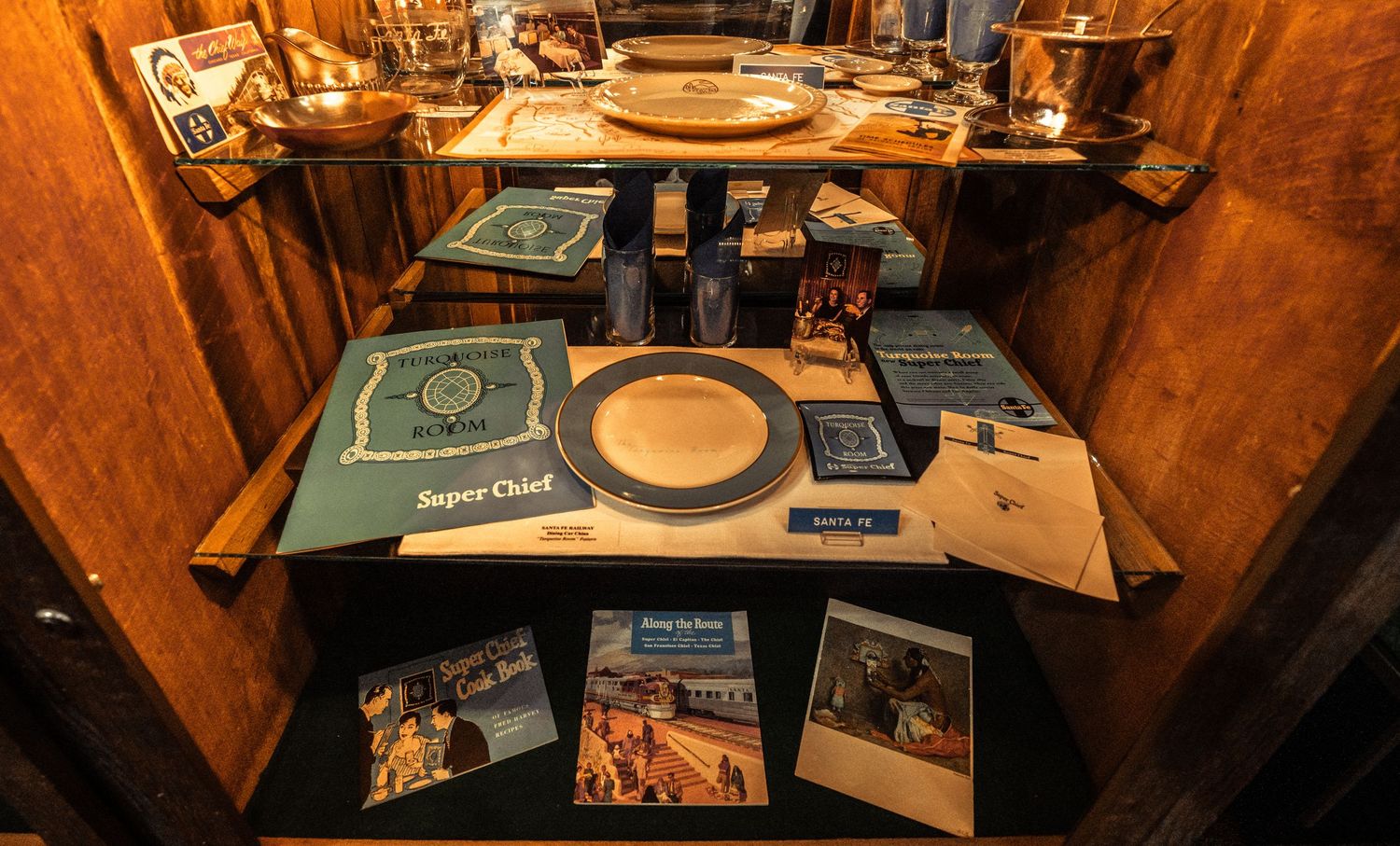 Museum exhibit showcasing historical railroad documents and artifacts in illuminated display cases.