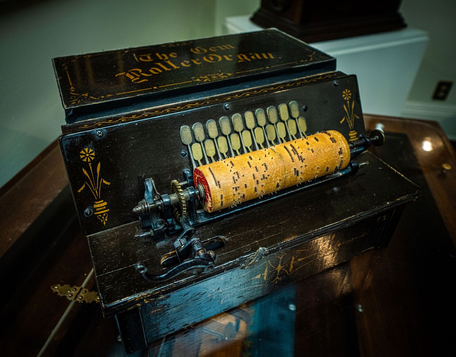 Vintage mechanical music box cylinder with ornate brass details and intricate pin patterns displayed in dramatic lighting.