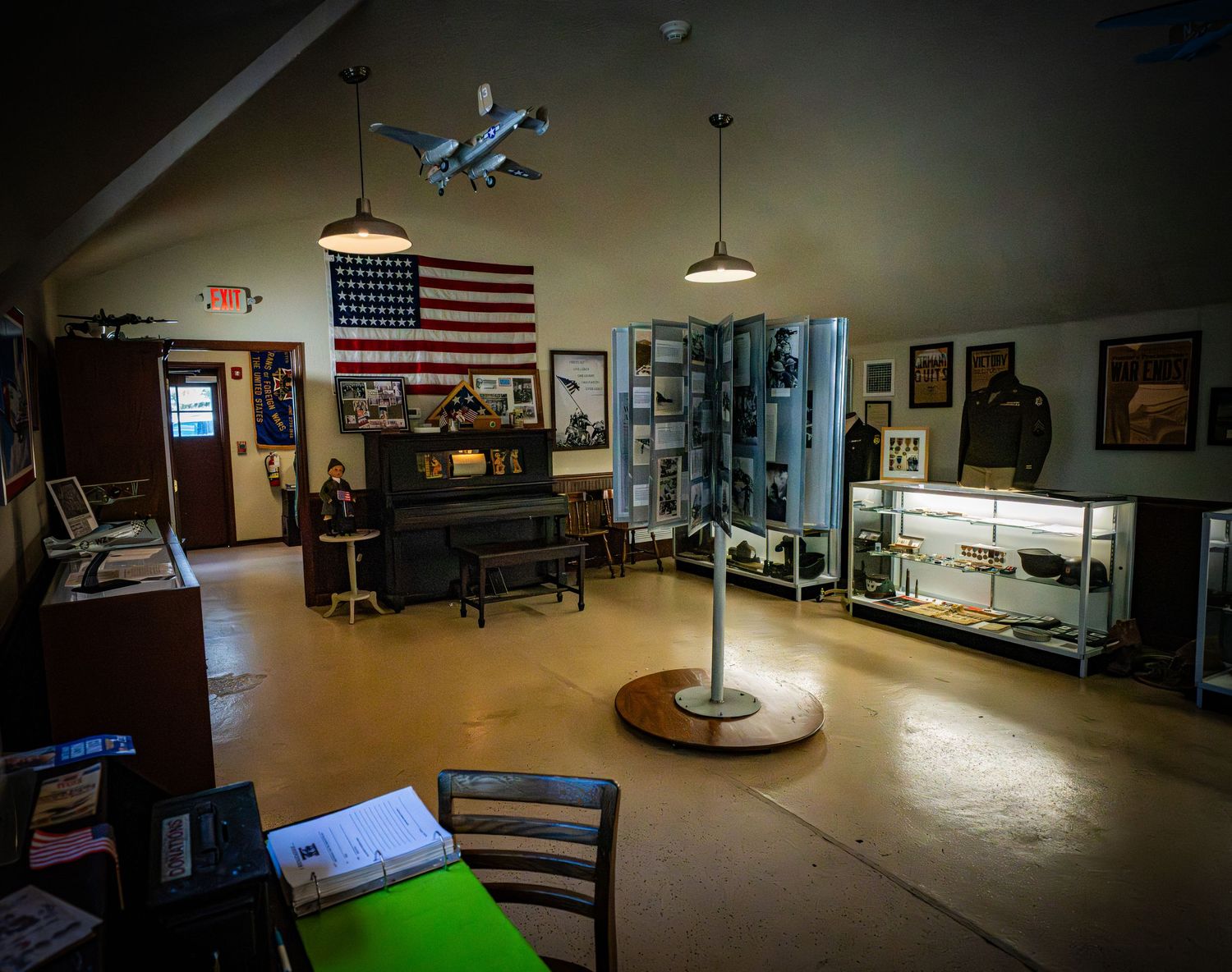 Museum interior space with American flag and display cases in dim lighting.