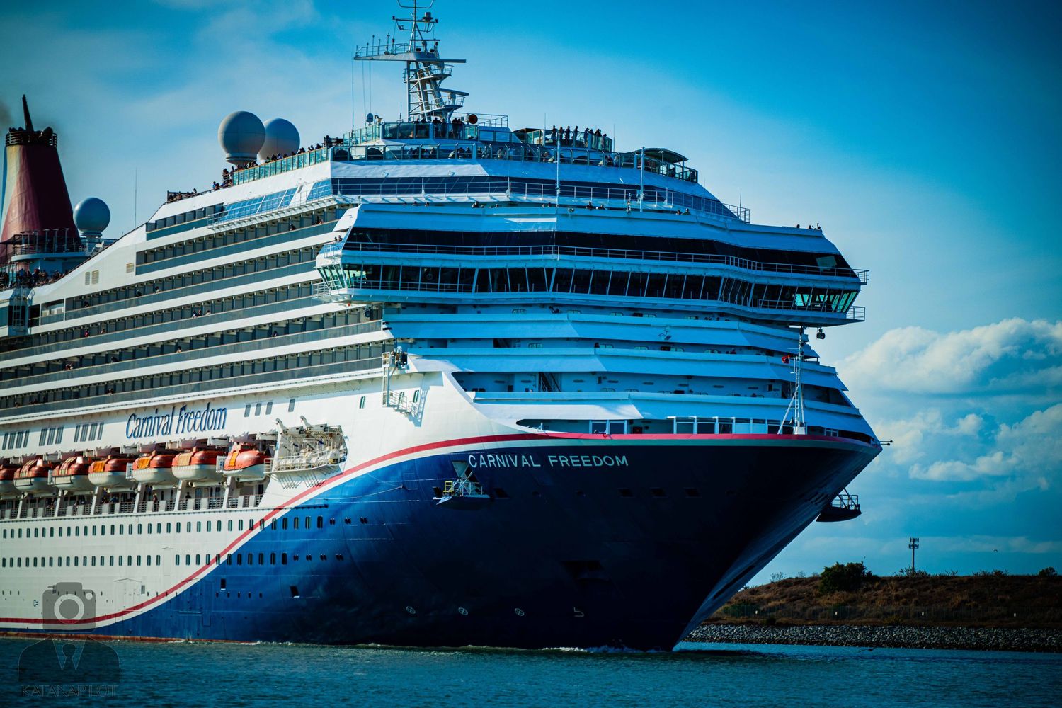 Large Disney cruise ship sailing on bright blue waters under sunny skies.