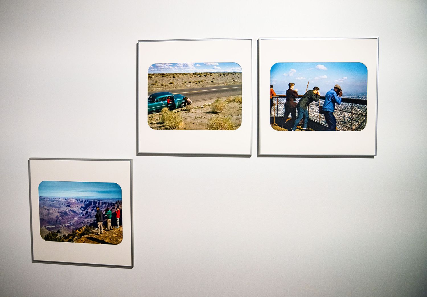 Museum wall featuring panoramic landscape photographs in white frames.