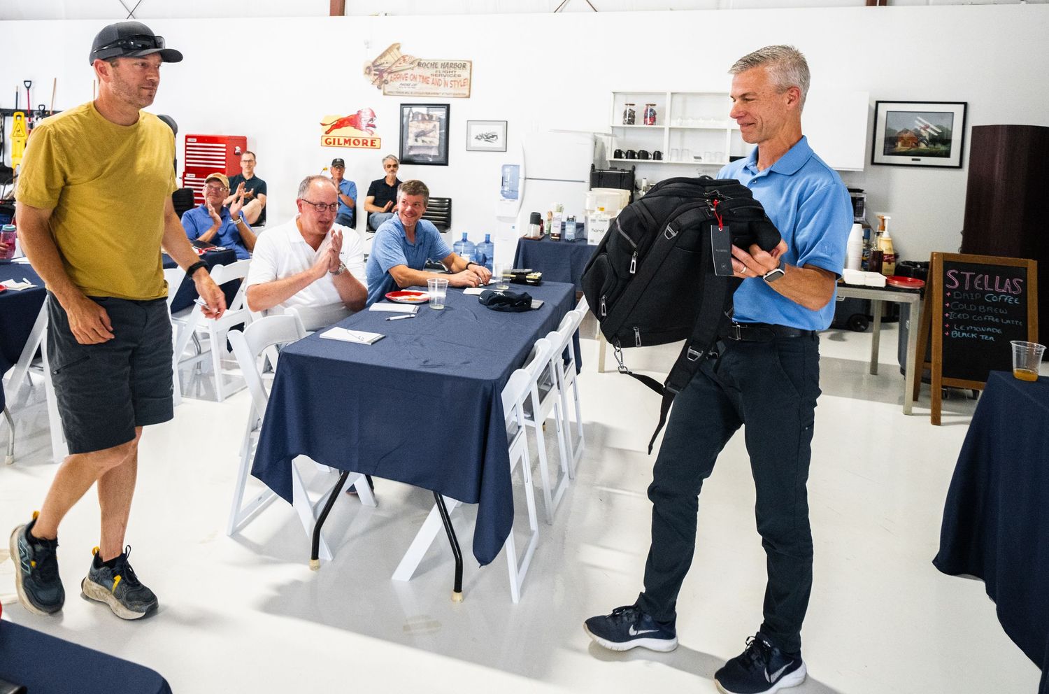 Meeting space with attendees viewing presentations on wall-mounted screens in an industrial setting.