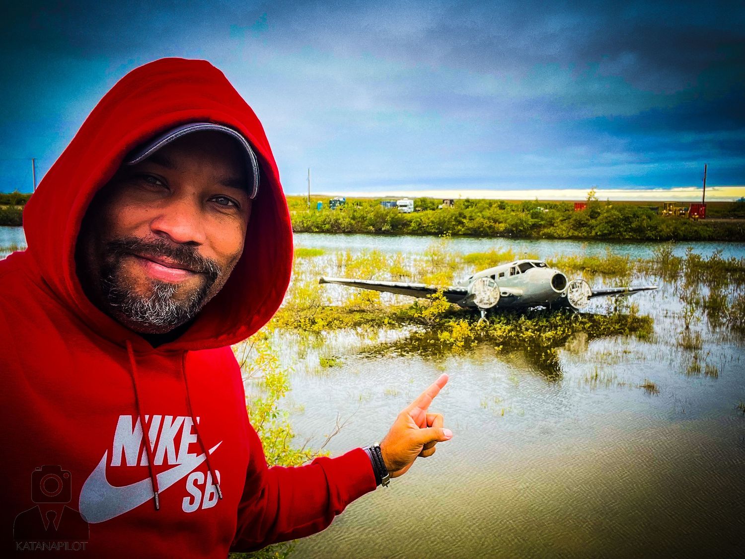 A flooded landscape with wetlands and water reflections under a dramatic sky in Nome, Alaska.