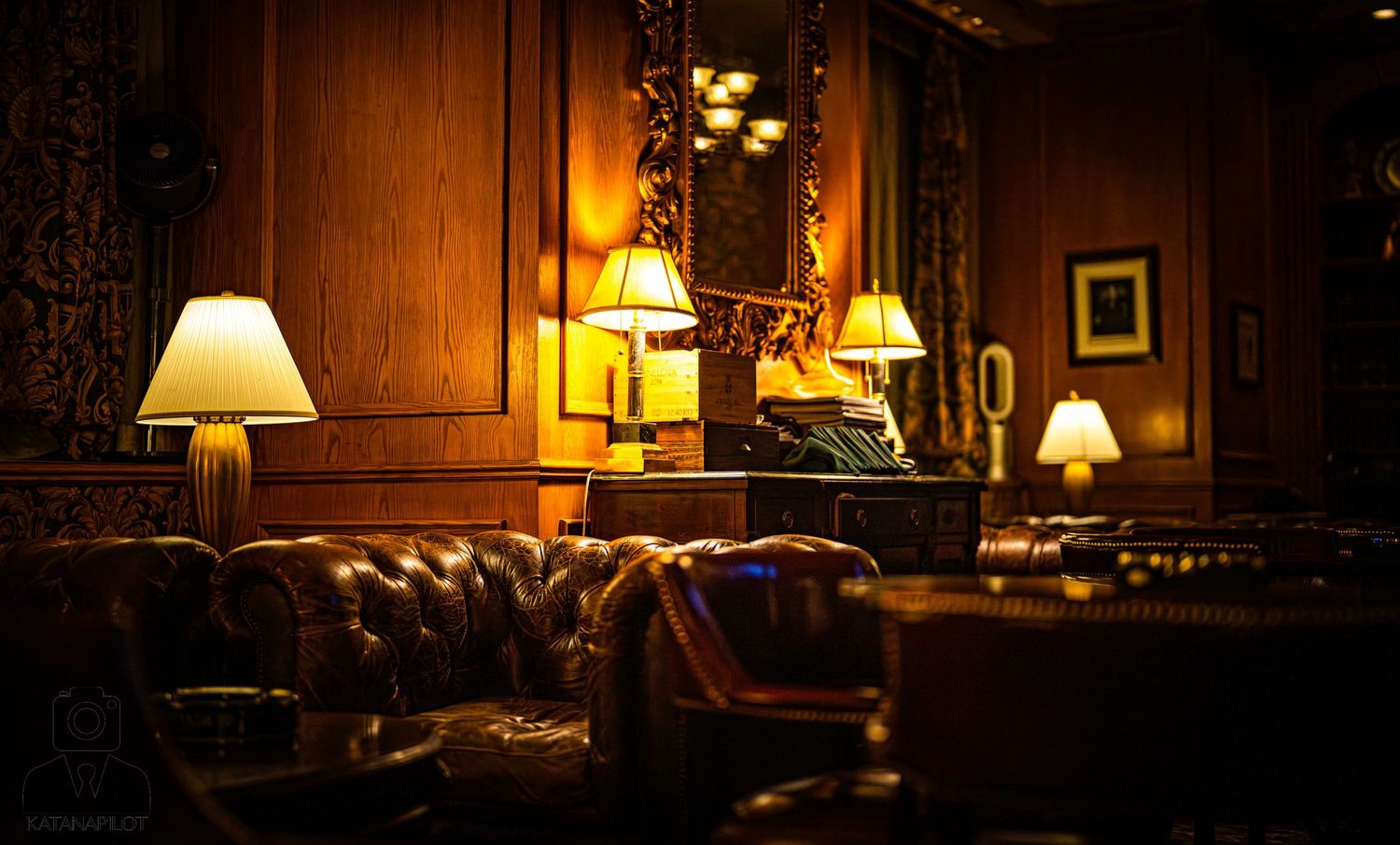 A cozy living room interior with warm lamp lighting and leather furniture creates an inviting ambiance.