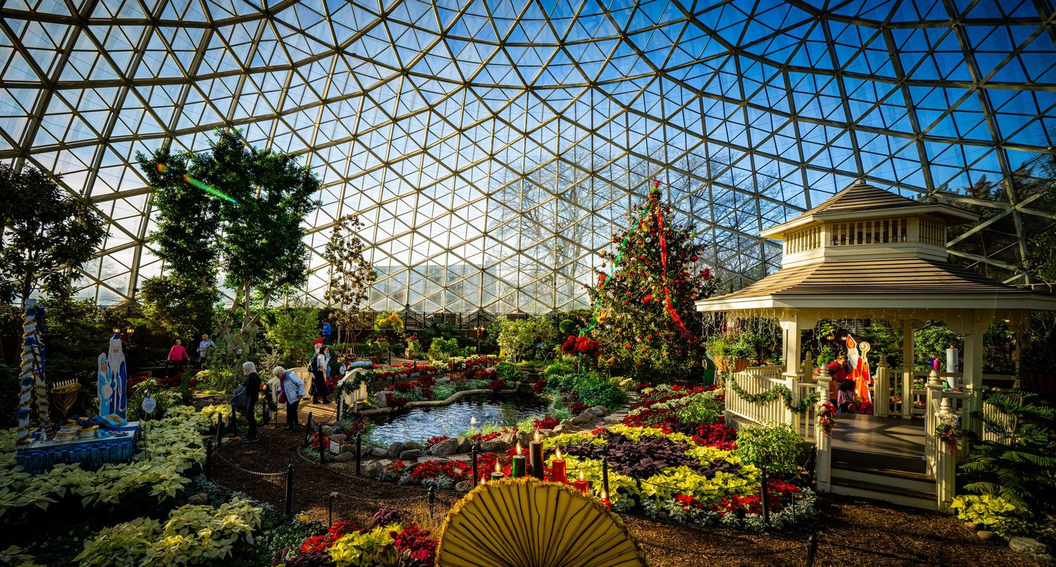 Stunning greenhouse conservatory with glass dome ceiling, flowers, and white gazebo.