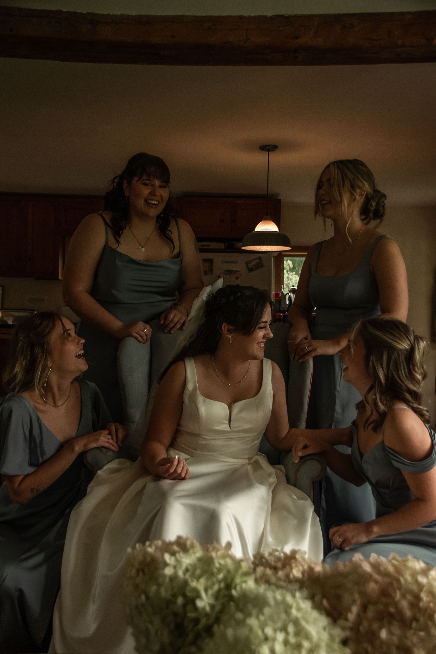 Enthusiastic wedding guests dancing and celebrating under a decorated tent with white drapes.