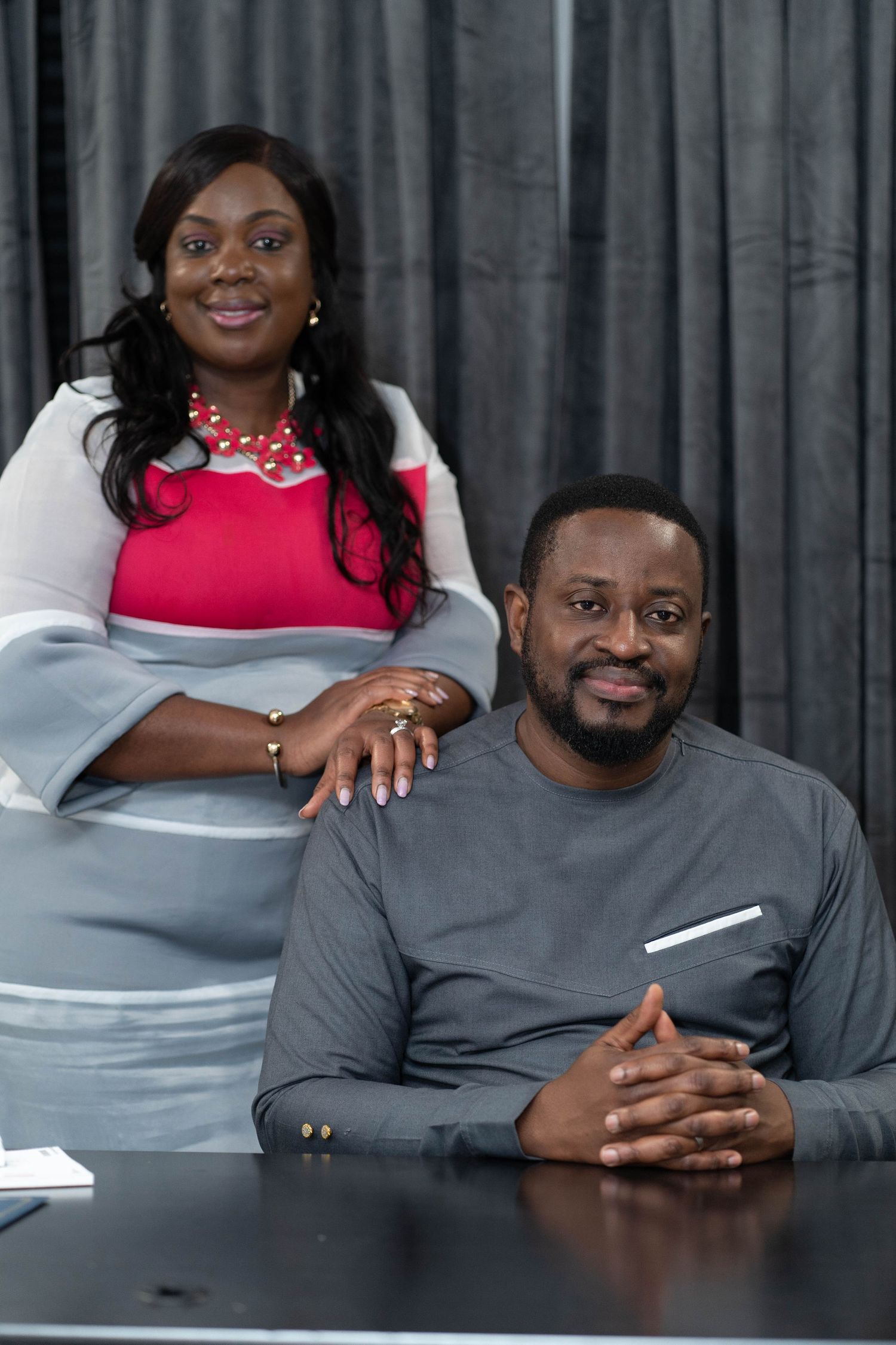 Professional couple in business attire seated at desk during corporate meeting.